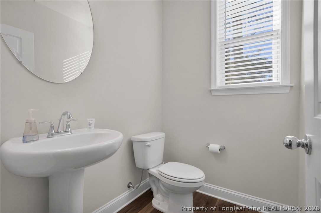 224 Timber Skip Drive Spring Lake, NC 28390 - Photo 6 of 30 a bathroom with a sink a toilet and a mirror