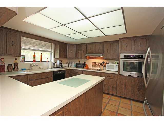 169 Southeast Wavecrest Way Boca Raton, FL 33432 - Photo 9 of 25 a kitchen with stainless steel appliances wooden cabinets a sink and a stove