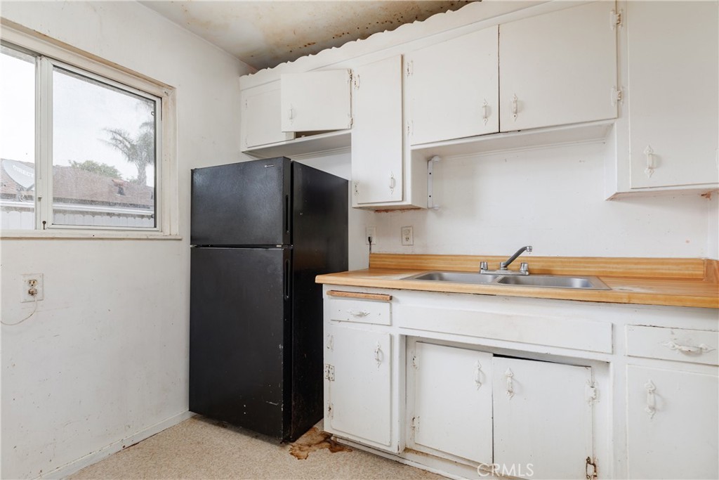 321 North K Street Lompoc, CA 93436 - Photo 14 of 32 a kitchen with a refrigerator sink and cabinets