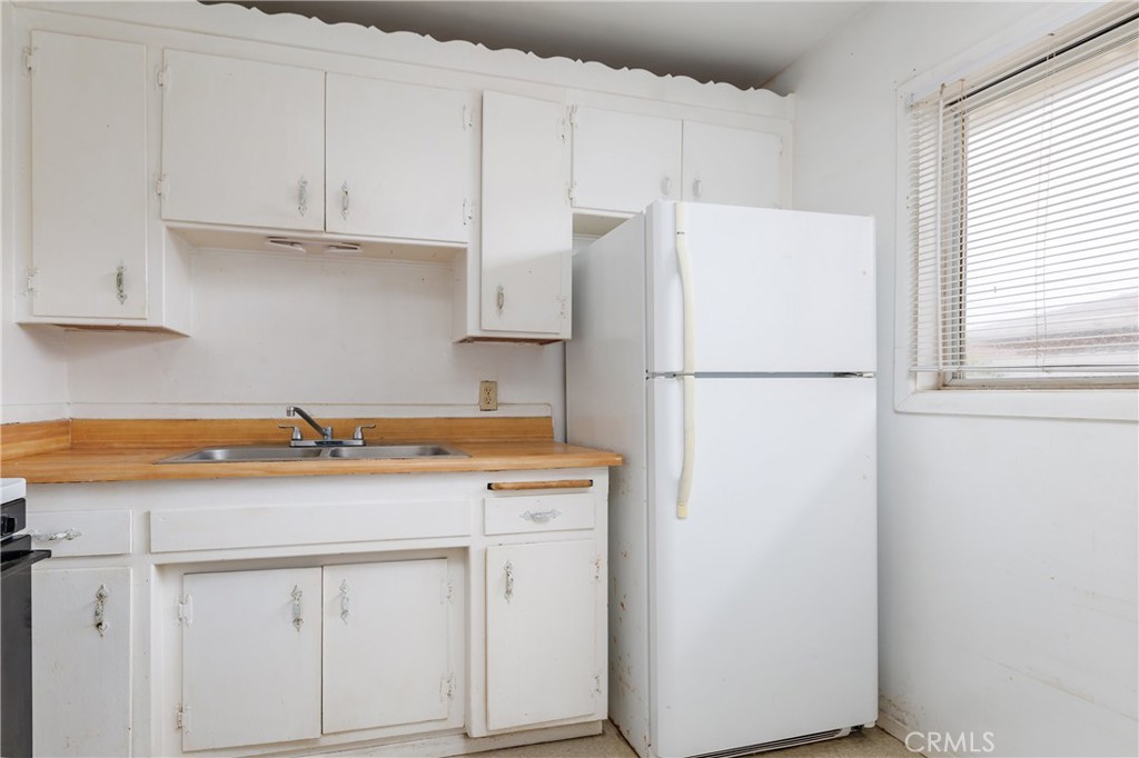 321 North K Street Lompoc, CA 93436 - Photo 19 of 32 a kitchen with stainless steel appliances white cabinets and a refrigerator