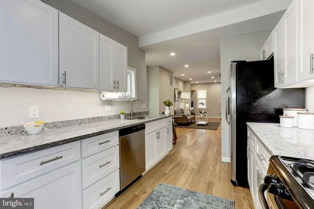a kitchen with granite countertop a sink stove and cabinets