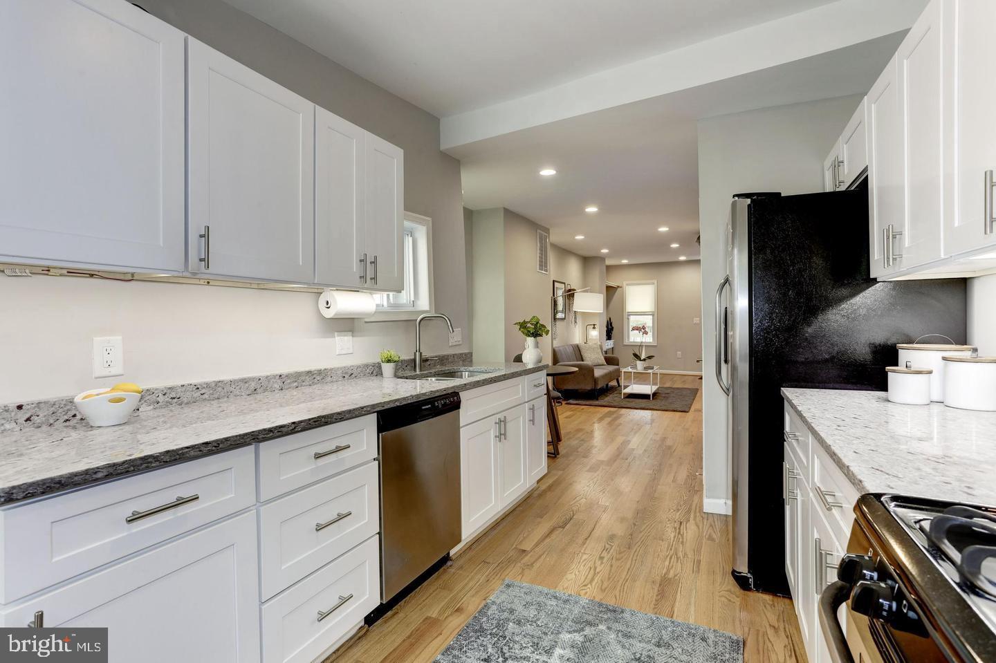 1816 Minnesota Avenue Southeast Washington, DC 20020 - Photo 3 of 13 a kitchen with granite countertop a sink stove and cabinets