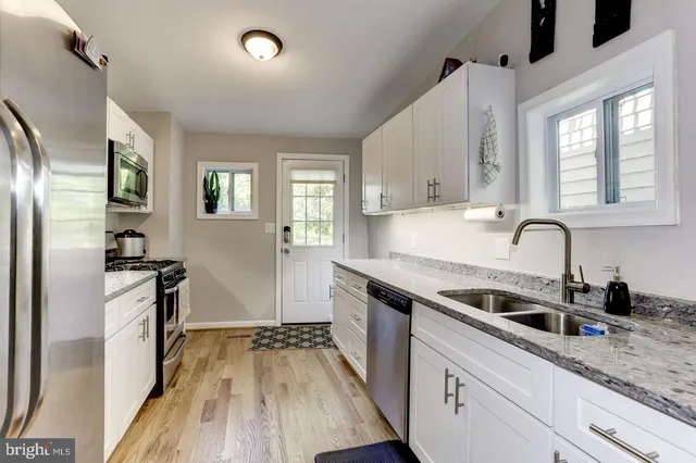 a kitchen with granite countertop a sink stove and refrigerator