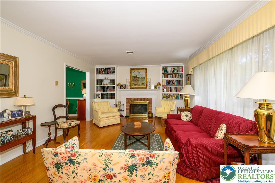 2516 Rachael Lane Orefield, PA 18069 - Photo 12 of 45 Hardwood flooring flows throughout this cozy living area, anchored by a traditional brick fireplace and built-in shelving.