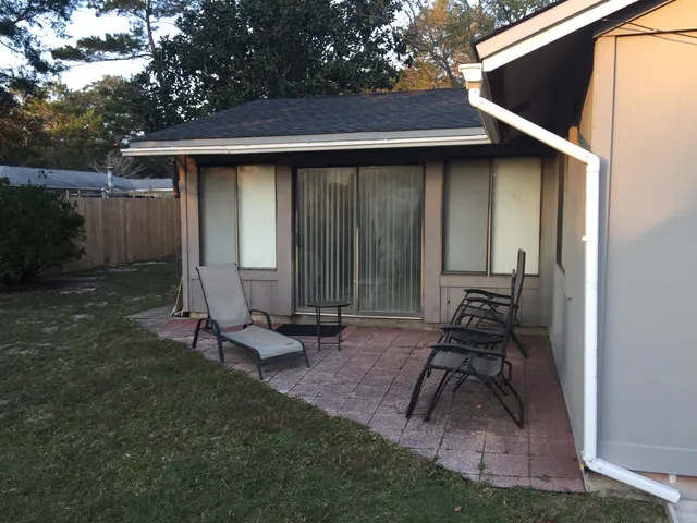 a backyard of a house with table and chairs
