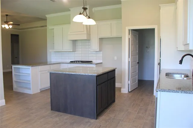 a kitchen with a sink a counter space and cabinets