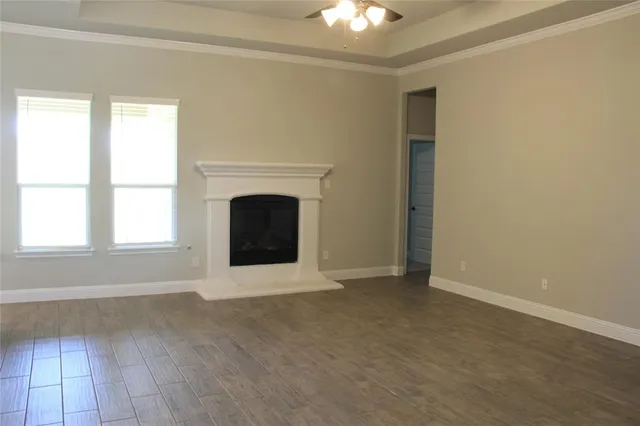 an empty room with windows and fireplace