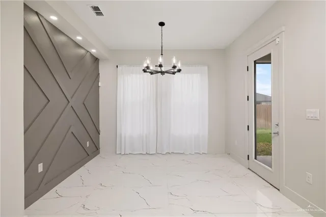 a view of a hallway with chandelier and entryway