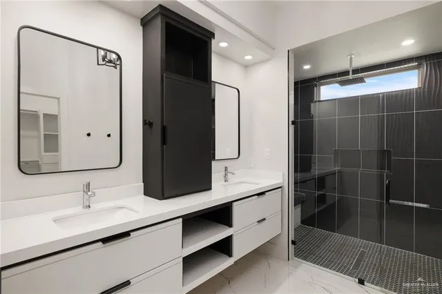 a bathroom with a double vanity sink mirror and shower