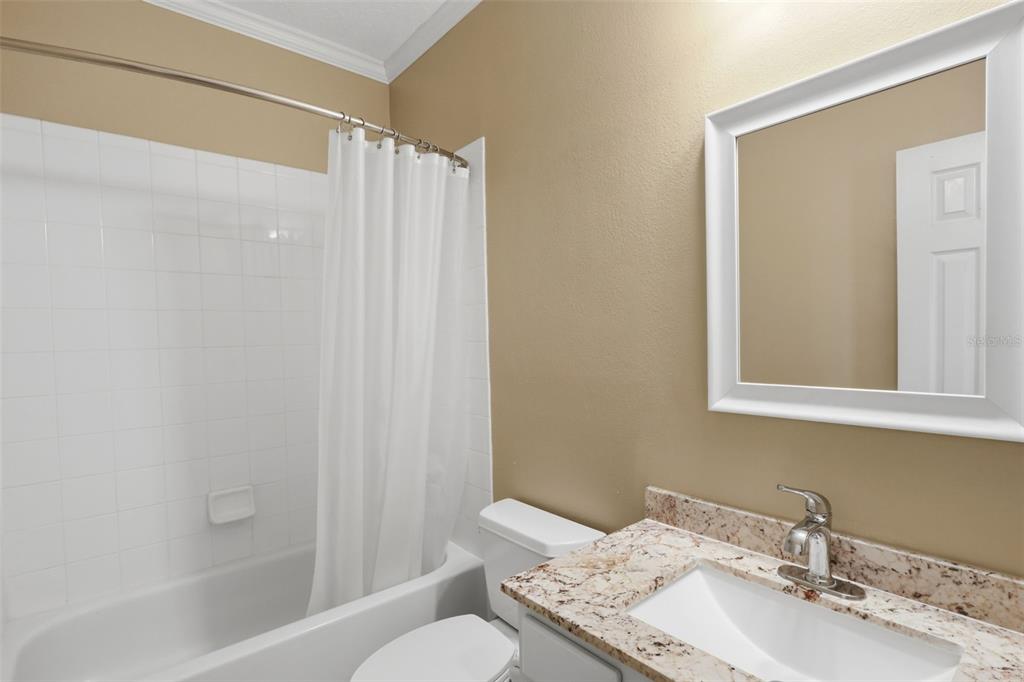 907 Pawstand Road Celebration, FL 34747 - Photo 28 of 49 a bathroom with a granite countertop sink toilet and shower