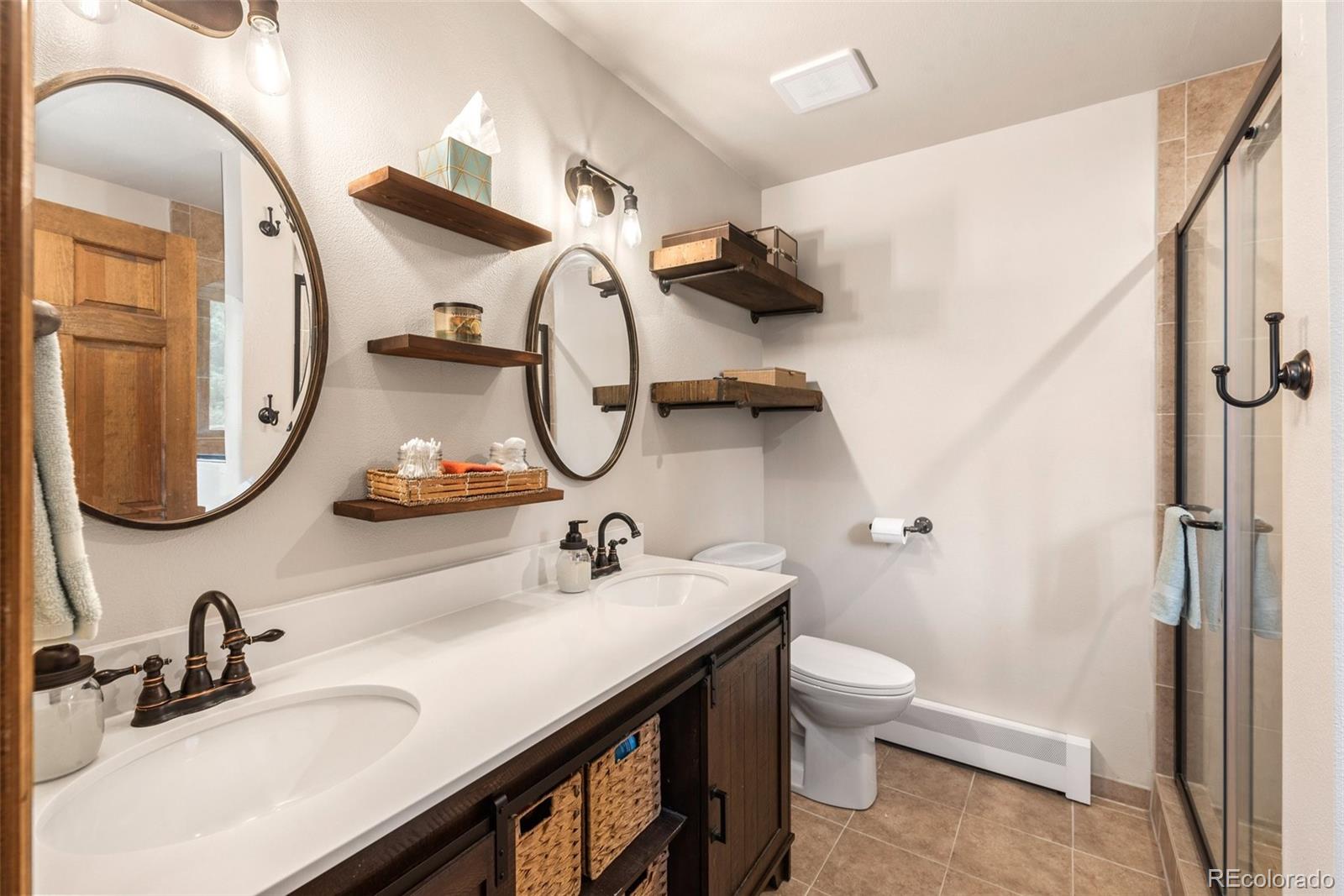 30540 Rand Road Conifer, CO 80433 - Photo 13 of 37 a bathroom with a double vanity sink mirror and toilet