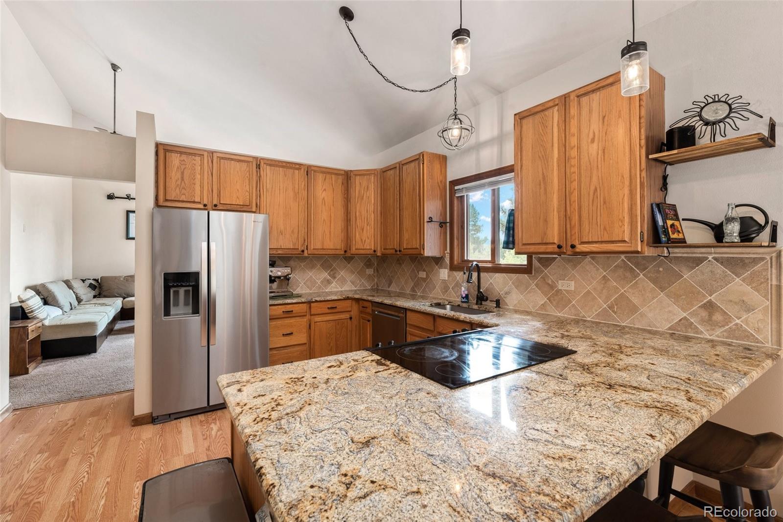 30540 Rand Road Conifer, CO 80433 - Photo 7 of 37 a kitchen with kitchen island granite countertop a sink stove and refrigerator