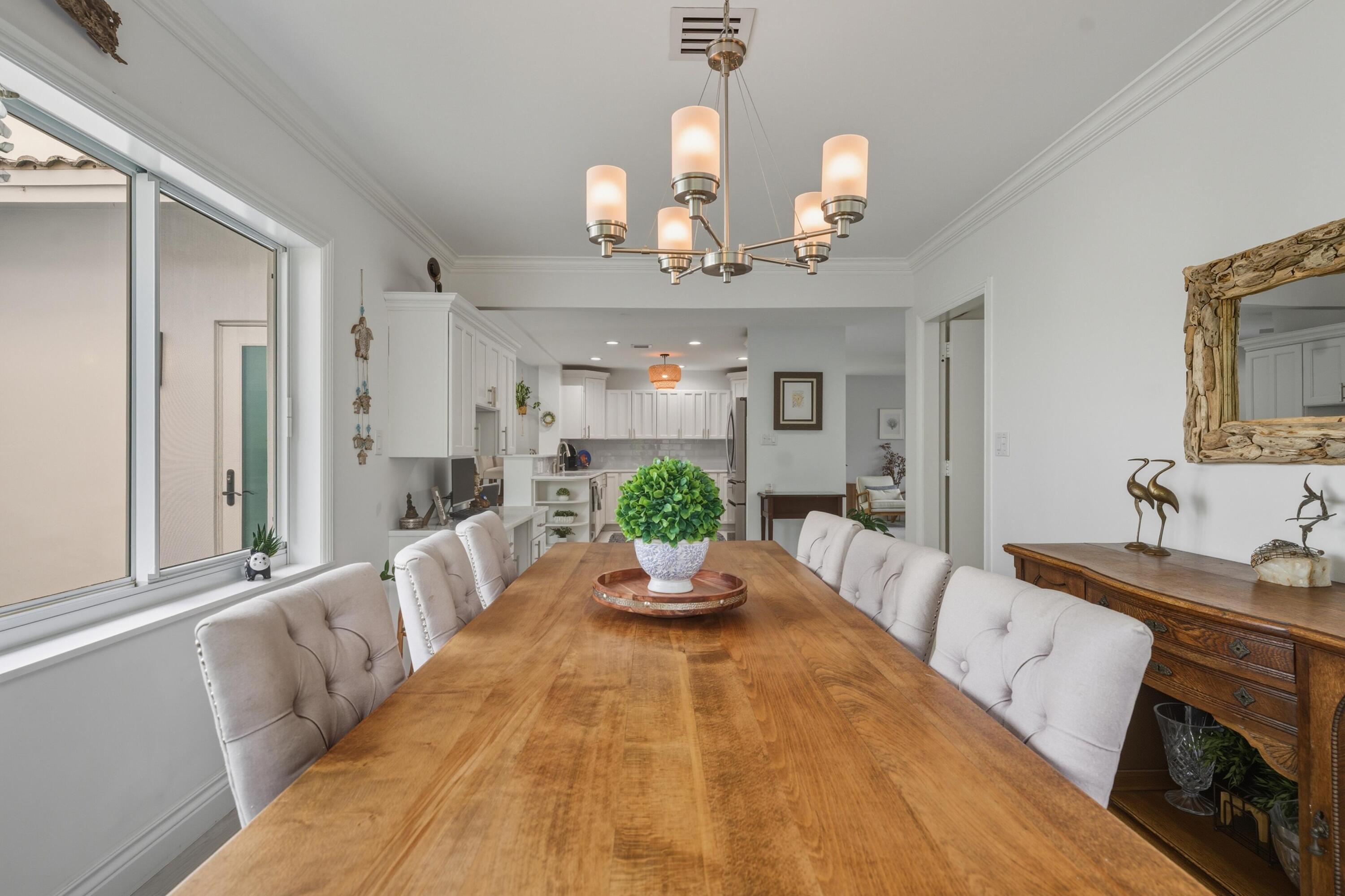2642 Northeast 26th Terrace Lighthouse Point, FL 33064 - Photo 32 of 53 a view of a dining room with furniture a chandelier and wooden floor