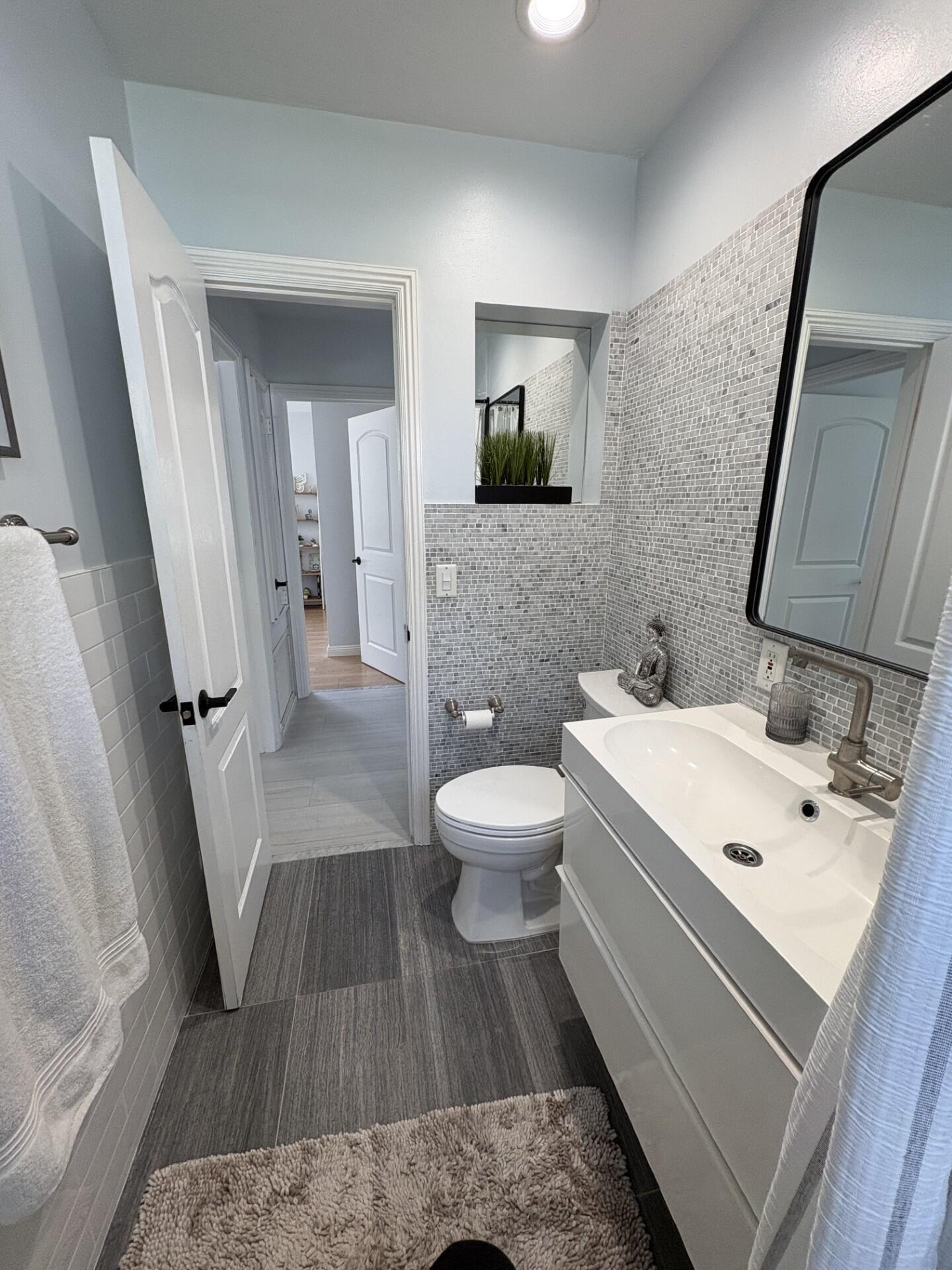 2642 Northeast 26th Terrace Lighthouse Point, FL 33064 - Photo 40 of 53 a bathroom with a sink a toilet and mirror