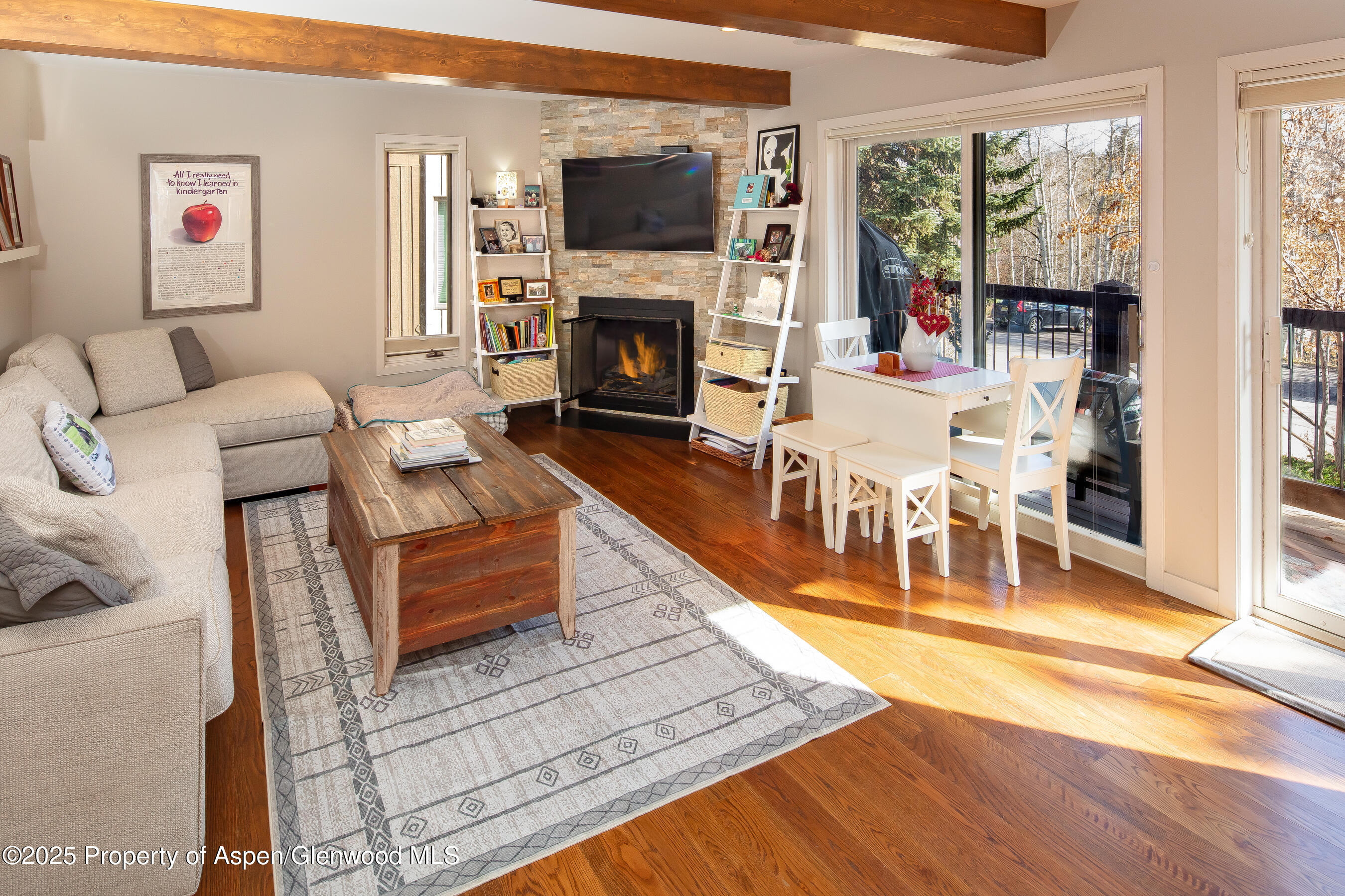 35 Upper Woodbridge Road, Unit 28A Snowmass Village, CO 81615 - Photo 6 of 13 a living room with furniture a flat screen tv and a fireplace