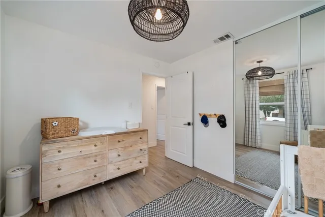 a view of a bedroom with furniture and wooden floor