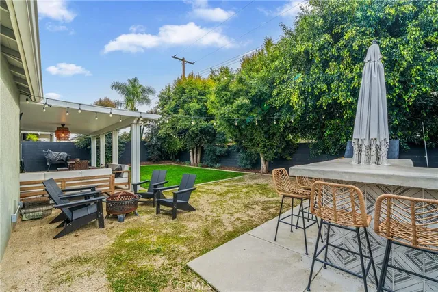 a view of a swimming pool with a table and chairs under an umbrella