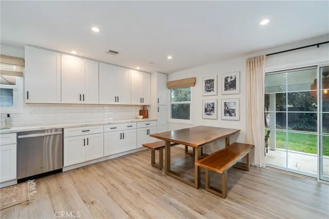 a living room with stainless steel appliances granite countertop a sink and wooden floor