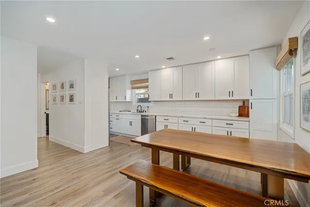 a kitchen with a table chairs refrigerator and cabinets