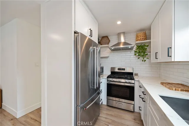 a kitchen with stainless steel appliances a stove a refrigerator and a microwave