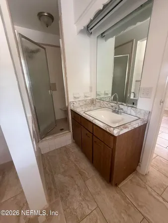 a bathroom with a granite countertop sink and a mirror