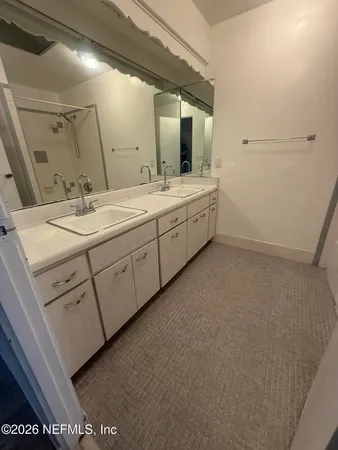 a bathroom with a double vanity sink and mirror