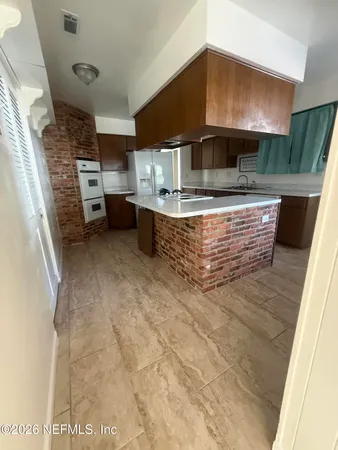 a view of kitchen with stainless steel appliances kitchen island granite countertop a stove and a sink