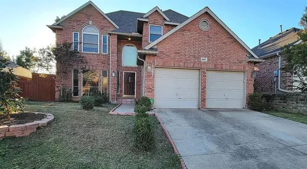 a view of a house with a yard plants and a garage