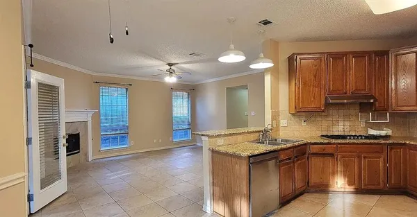 a kitchen with kitchen island granite countertop a refrigerator and a stove top oven