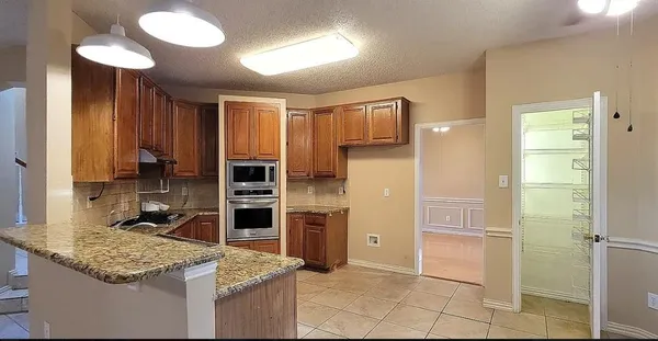 a kitchen with kitchen island granite countertop a stove top oven microwave and refrigerator