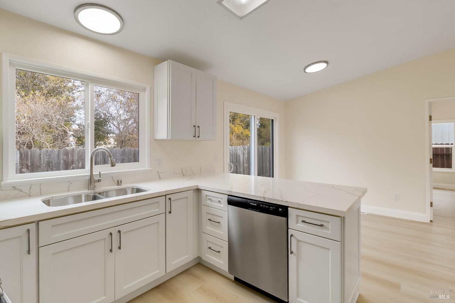 2555 Flosden Road, Unit 8 American Canyon, CA 94503 - Photo 17 of 58 a kitchen with white cabinets and a large window