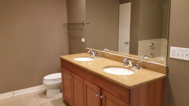 450 Village Center Drive, Unit 414 Burr Ridge, IL 60527 - Photo 6 of 10 a bathroom with a sink toilet and a mirror