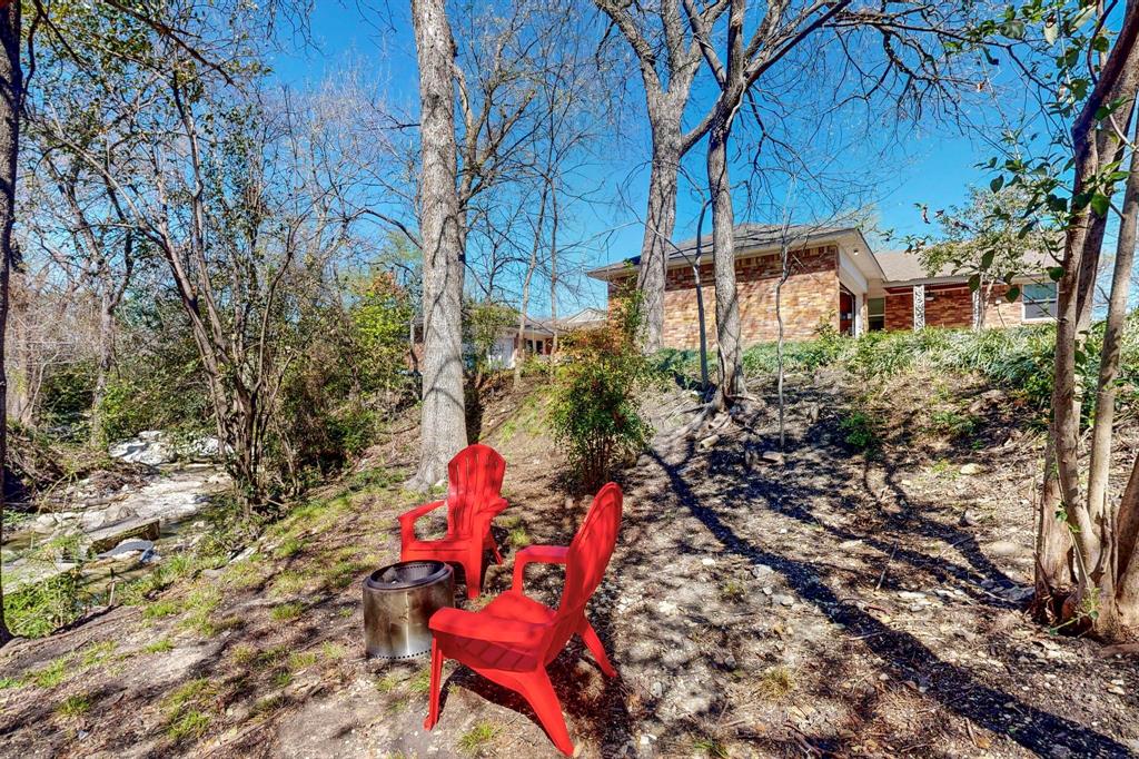 2120 Healey Drive Dallas, TX 75228 - Photo 39 of 39 a backyard of a house with table and chairs under an umbrella