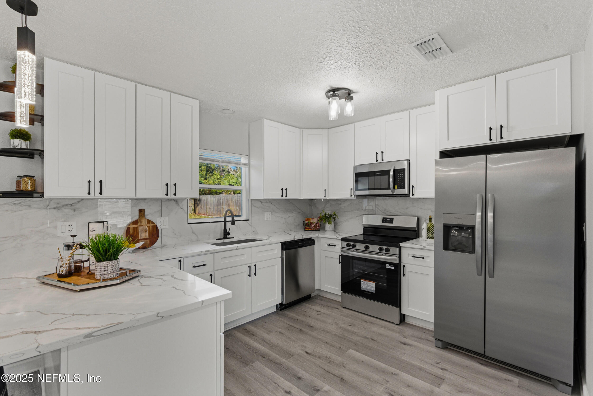 3631 North Ride Drive Jacksonville, FL 32223 - Photo 11 of 30 a kitchen with stainless steel appliances granite countertop a stove a sink dishwasher a refrigerator and a microwave with wooden floor
