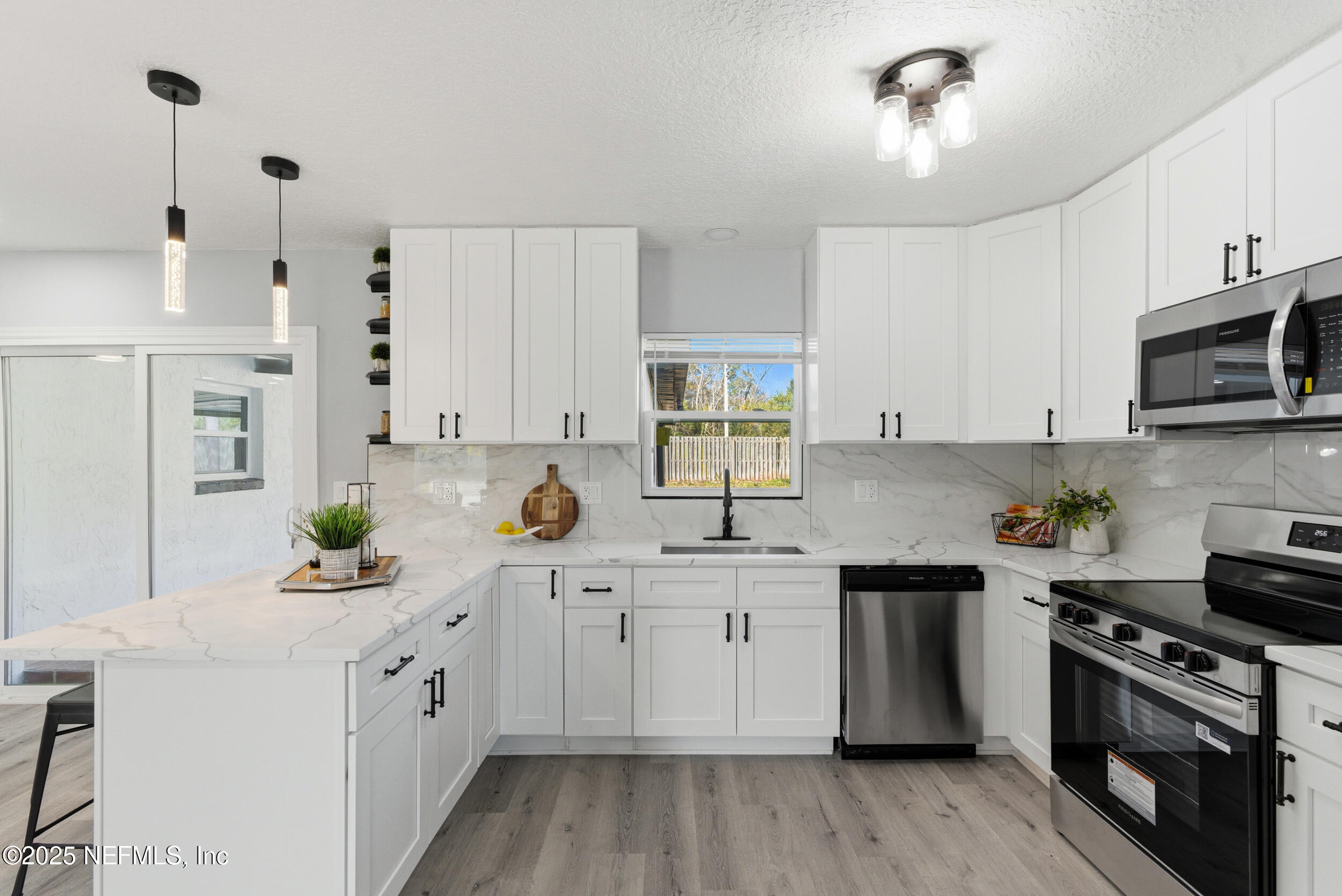 3631 North Ride Drive Jacksonville, FL 32223 - Photo 7 of 30 a kitchen with stainless steel appliances a sink stove and white cabinets