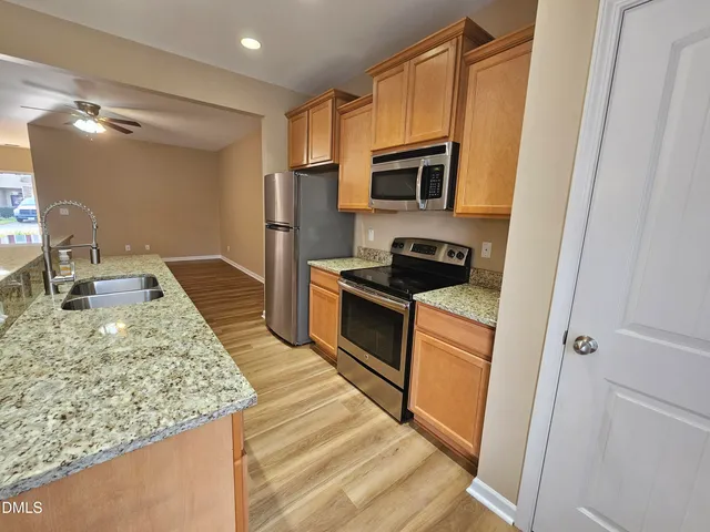 a kitchen with stainless steel appliances granite countertop a sink stove and refrigerator