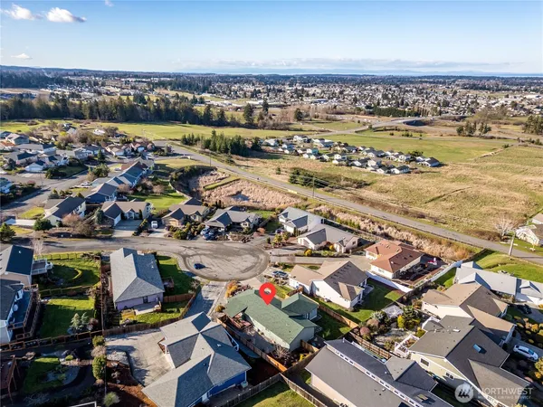 an aerial view of a city with lots of residential buildings and ocean view in back