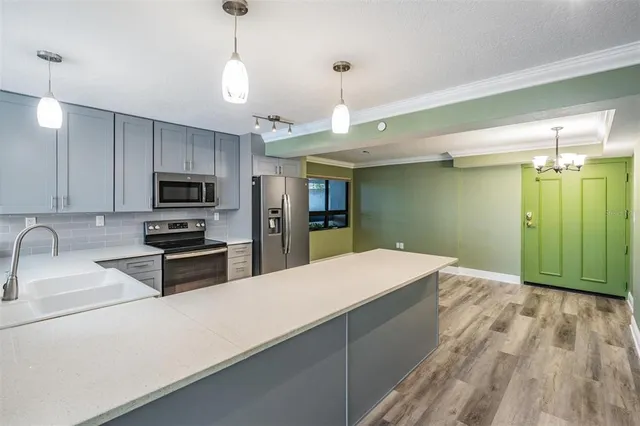 a kitchen with kitchen island white cabinets and stainless steel appliances