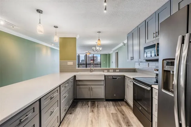 a kitchen with a sink stainless steel appliances cabinets and a counter space