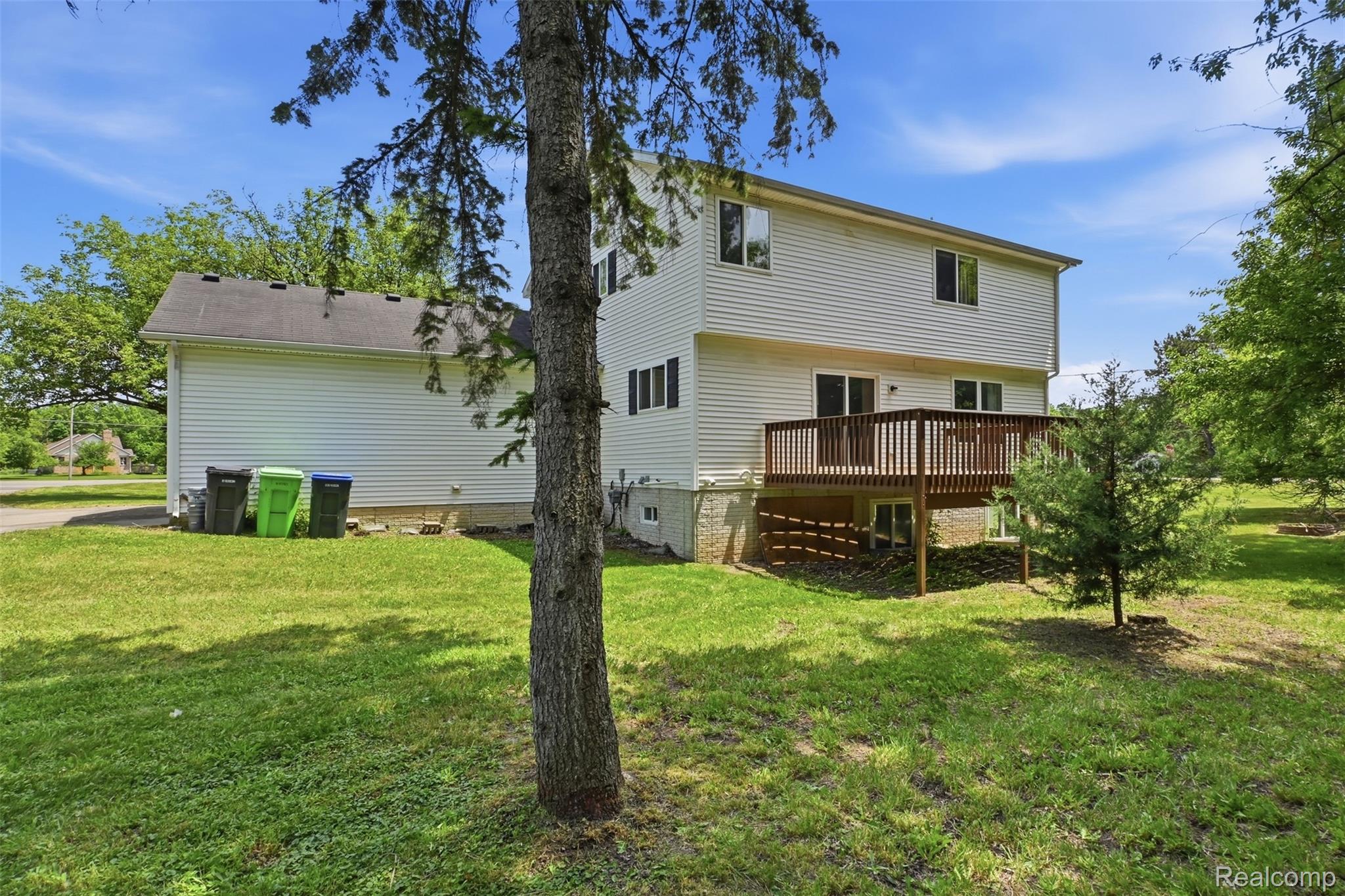 4482 Pleasant Valley Road Brighton, MI 48114 - Photo 25 of 35 Rear exterior featuring a two-story design with white siding, a wooden deck, and a green lawn