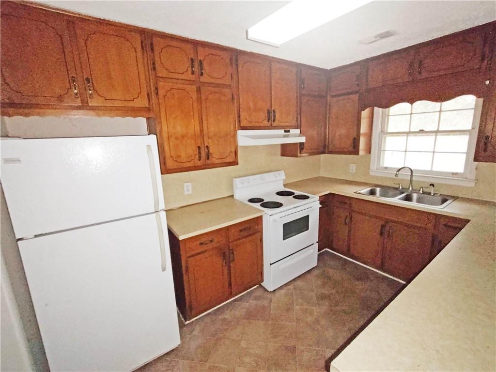 497 Highway 212 Covington, GA 30016 - Photo 5 of 14 a kitchen with a refrigerator sink stove and cabinets
