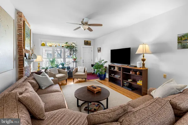 a living room with furniture a flat screen tv and a window