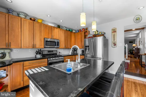 a kitchen with stainless steel appliances granite countertop a sink a stove and a refrigerator