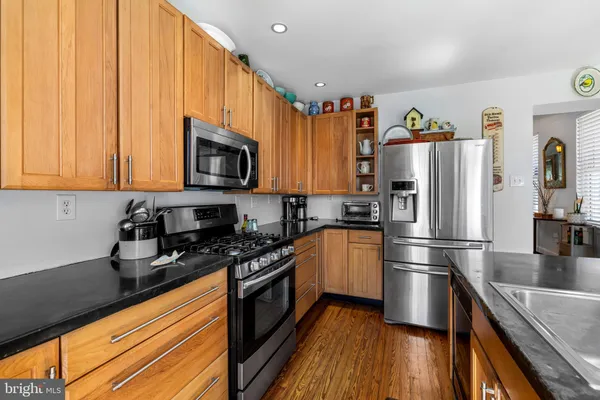 a kitchen with granite countertop a refrigerator stove and microwave