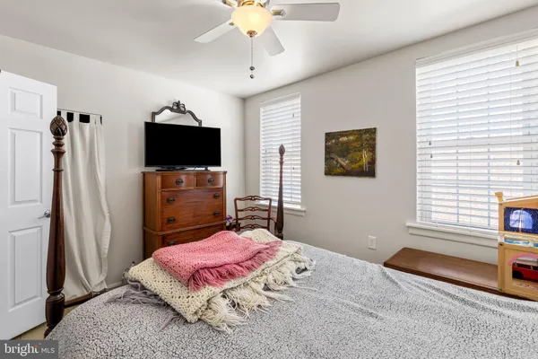 a bedroom with a bed flat screen tv and a window