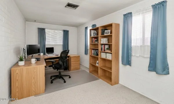 a view of a workspace with furniture and a window