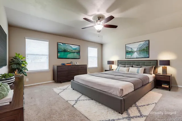 a spacious bedroom with a bed and a flat screen tv