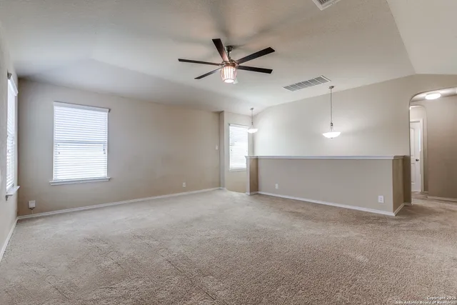 an empty room with windows and fan