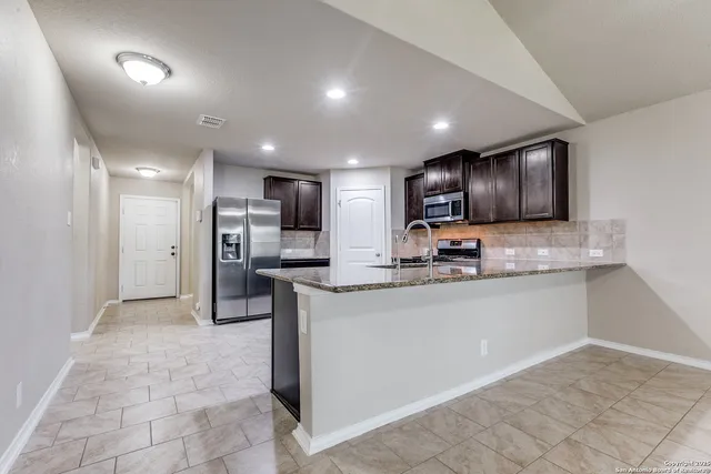 a kitchen with stainless steel appliances granite countertop a refrigerator sink and cabinets