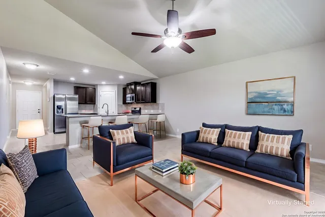 a living room with furniture kitchen view and a chandelier